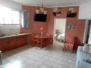 a kitchen and living room with a table and chairs at Peacefull Memories in Cintsa Mouth West