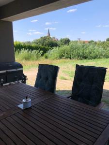 a wooden table with two chairs and a grill at Apartament Maria in Gietrzwałd