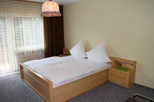- une chambre avec un lit doté de draps blancs et une fenêtre dans l'établissement Gasthaus Zum Hohenstein, à Ober-Kainsbach