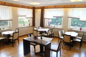 - une salle à manger avec des tables, des chaises et des fenêtres dans l'établissement Gasthaus Zum Hohenstein, à Ober-Kainsbach