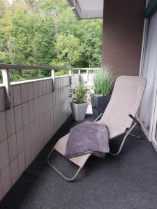 uma cadeira sentada numa varanda com plantas em Ferienwohnung Domicile chic mit Schwimmbad und Saunanutzung em Bad Harzburg