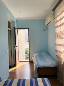1 dormitorio con 1 cama y puerta corredera de cristal en Haer B&B, en Meghri