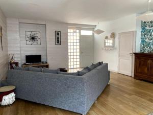 uma sala de estar com um sofá azul numa sala de estar em la maison du dauphin em Marans