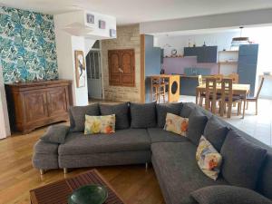 uma sala de estar com um sofá e uma cozinha em la maison du dauphin em Marans
