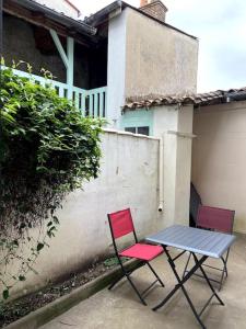duas cadeiras e uma mesa em frente a uma cerca em la maison du dauphin em Marans