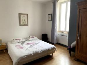 馬朗的住宿－la maison du dauphin，一间卧室,床上有粉红色的鲜花