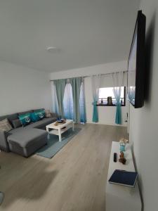 a living room with a couch and a tv at PARADISE BEACH Apartment, with wifi and stunning sea views in Adeje