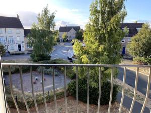 Cette chambre dispose d'un balcon offrant une vue sur la rue. dans l'établissement Modern Penthouse - 2 Bed, 2 Bath, 2 Gated Parking, à Wellingborough