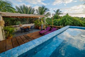 a swimming pool with a deck and a table and chairs at Sky Atins Rooftop in Atins