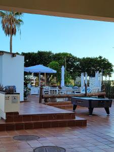 a patio with a pool table and chairs at PARADISE BEACH Apartment, with wifi and stunning sea views in Adeje +23 photos