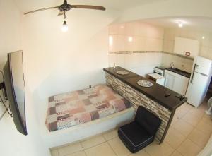 Kleines Zimmer mit einem Bett und einer Küche in der Unterkunft 4 Estações Arraial - Casa Verde in Arraial do Cabo