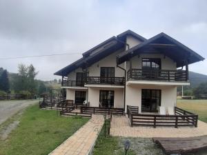 a large house with a lot of benches in front of it at Apartman Popadić-Goč in Biserske Kuće