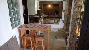 a small kitchen with a table and two stools at La Roca Studio 7 in Praia do Rosa