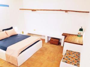 - une chambre blanche avec un lit et du parquet dans l'établissement CALA Guane Barichara, à Guarne