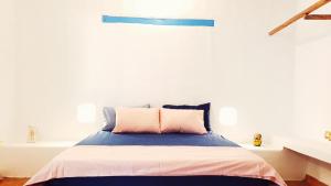 Bett mit rosa und blauer Bettwäsche in einem Zimmer in der Unterkunft CALA Guane Barichara in Guarne