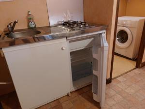 a kitchen with a stove and a sink and a washing machine at Chambre Familiale in Treignac
