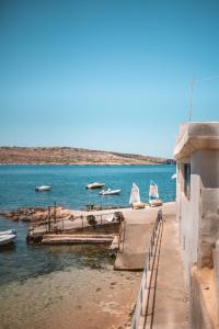 a group of boats sitting on a dock in the water at The 1930's Maltese Residence in St. Paul's Bay