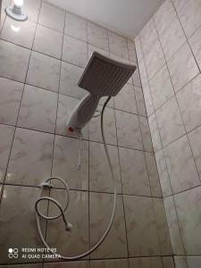 a shower head on a tiled bathroom floor at Casa Agradável próxima ao Bosque in Pôrto Feliz