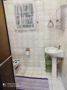 un bagno bianco con lavandino e WC di Casa Agradável próxima ao Bosque a Porto Feliz