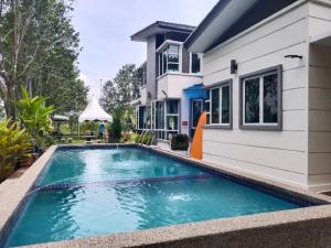 a swimming pool in front of a house at Laman Jubilee DBayu in Mantin