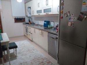 a kitchen with white cabinets and a stainless steel refrigerator at Trabzon Luxury Homes in Trabzon