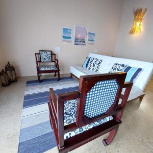 a living room with a couch and a chair at Coco Pontall Bangalôs in Coruripe