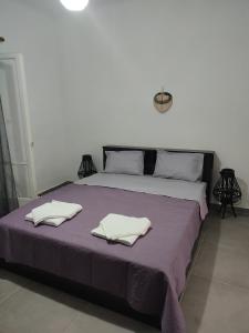 a bedroom with a bed with two towels on it at Victory's house, 3min walk to Skala's sandy beach in Skala