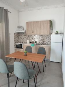 a kitchen with a table and chairs and a refrigerator at Victory's house, 3min walk to Skala's sandy beach in Skala
