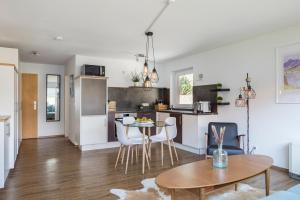 a kitchen and living room with a table and chairs at Design Apartment „Alpenglühen“ nahe Breitachklamm in Oberstdorf