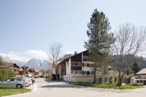 a building on a street with a tree at Design Apartment „Alpenglühen“ nahe Breitachklamm in Oberstdorf