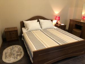 1 dormitorio con 1 cama grande y cabecero de madera en Old batumi apartment on kostava 9 en Batumi