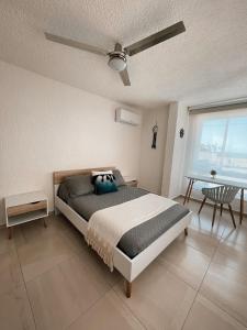 a bedroom with a bed and a ceiling fan at Hermoso Departamento Nuevo a 50 metros de playa!! in Manzanillo +55 photos