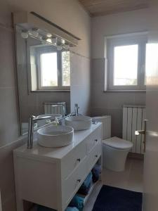 a bathroom with two sinks and a toilet at Cosy Home in South Alsace for work and leisure in Pfastatt