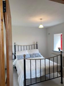 a bedroom with a bed with white sheets and a window at The Old Mill, Kilcorkey, Bellanagare, Castlerea, County Roscommon - West of Ireland in Bellanagare