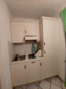 a small kitchen with white cabinets and a sink at Appartamento a Punta Asfodeli in Porto Rotondo +6 photos