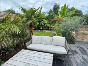 a white couch sitting on top of a wooden deck at MayGrove Retreat - Sleeps 2 - Jacuzzi & boat hire in Staines