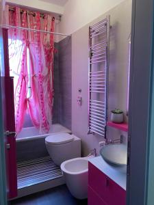 Baño de color rosa con aseo y lavamanos en Petit place incantevole a due passi da Milano!, en Cologno Monzese