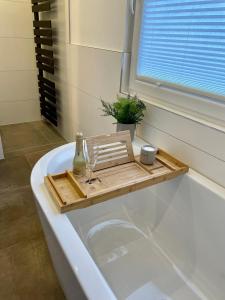 a bath tub with a tray and wine glasses on it at Neu! Wellnesshome Fontaneweg Sauna, Terasse, Garten Erstbezug Juli 2022 in Espelkamp