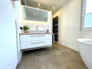 Baño blanco con lavabo y aseo en Neu! Wellnesshome Fontaneweg Sauna, Terasse, Garten Erstbezug Juli 2022 en Espelkamp