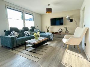 a living room with a couch and a table at Neu! Wellnesshome Fontaneweg Sauna, Terasse, Garten Erstbezug Juli 2022 in Espelkamp