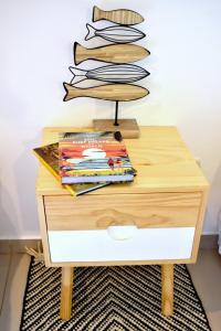 a wooden table with a stack of books on it at Refugio Surf Lodge in Tamarindo
