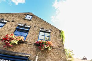a brick building with windows and flowers on it at A superb large 1 bedroom apartment in Ramsbottom in Ramsbottom