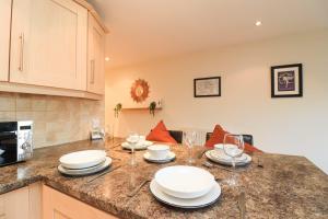 a kitchen with a table with plates and wine glasses at A superb large 1 bedroom apartment in Ramsbottom in Ramsbottom