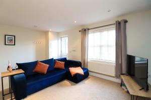 a living room with a blue couch and a television at A superb large 1 bedroom apartment in Ramsbottom in Ramsbottom