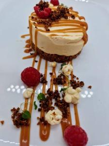 a piece of cake on a white plate with raspberries at The Woolpack Inn in Kettering