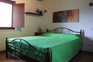 a green bed in a bedroom with a window at Il Pagliarello di Villa San Giovanni in San Demetrio neʼ Vestini
