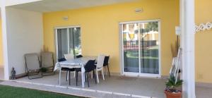 a patio with a table and chairs and a yellow wall at T2 Encosta sao jose guia albufeira in Albufeira