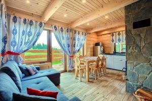a living room with a blue couch and a table at Cicha Przystań Dzianisz z sauną i jakuzi na wyłączność in Dzianisz