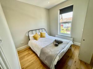 un dormitorio con una cama con un animal de peluche en Cosy 1 bedroom flat! en Londres