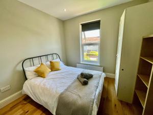 a bedroom with a bed with a stuffed animal on it at Cosy 1 bedroom flat! in London